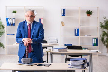 Old male employee unhappy with too much work in the office