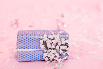 Close-up of a Christmas present on a blurred pink background.