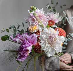 Close-up of a bright festive bouquet with chrysanthemums in female hands.