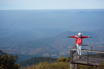 Fototapeta na wymiar Young woman raise hand up on top of mountain and sunrise. freedom travel adventure concept.