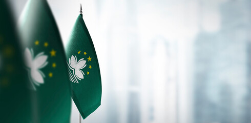 Small flags of Macao on a blurry background of the city