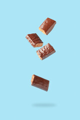 Different energy protein bar on blue background. Flying levitation