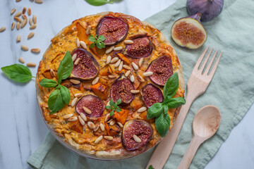 Home made autumn quiche with pumpkin and figs on a table
