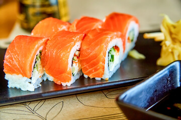 A California roll or California maki wrapped in salted salmon, is a makizushi sushi roll that is usually rolled inside-out, and containing cucumber, crab or imitation crab, and avocado.