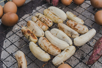 Grill bananas and egg is on charcoal stove which is popular street food.