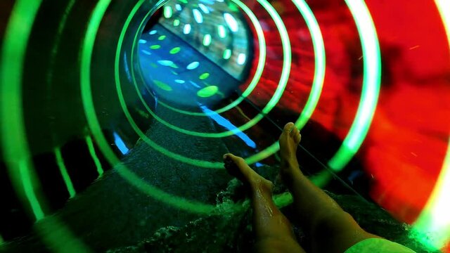 Teenager Boy Have Fun In A Closed Slider At Water Park. Fun On Water. Enjoying Water Slider Ride. Rider POV. Point Of View In Aqua Park Tube Slide. Summer Time. Multicolors View