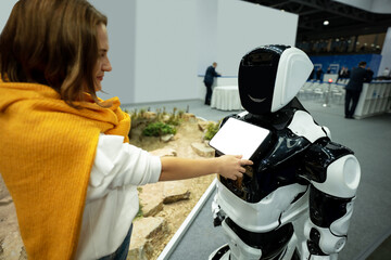 Woman using a touchscreen of a receptionist robot