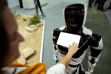 Woman using a touchscreen of a receptionist robot