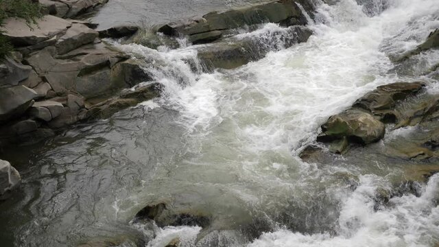 Magic foamy flows rushing over rocky cascade in the Carpathian mountains 