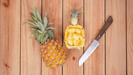 pineapple fruit and its pieces on a wooden background