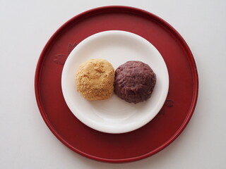 朱塗りのお盆にのったつぶ餡ときなこのおはぎ