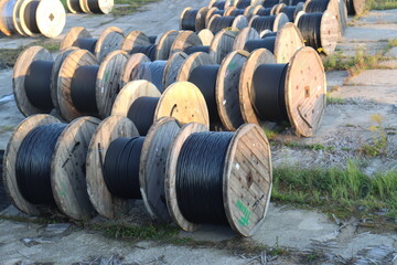 huge industrial reels of wires. Human-sized skeins with wires, industrial zone of a big city