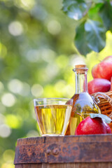 apple cider or juice in glass and bottle outdoors