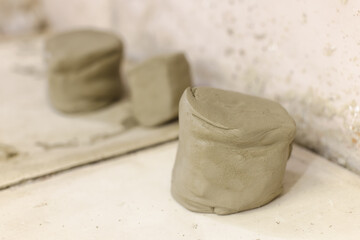 Clay ready for shaping on table in pottery art workshop.