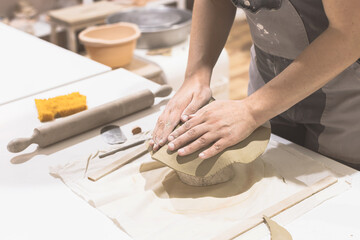 Obraz na płótnie Canvas Ceramic artist prepare clay for mold at table. Creative handmade craft
