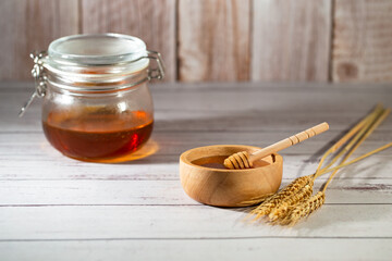 Sweet organic honey in wood bowl on gray wooden background. Honey contains antioxidants.  The same...