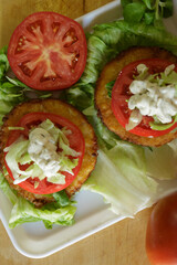 Pollo empanado con salsa, tomate y lechuga al estilo americano