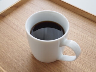 ウッドトレーにのったブラックコーヒー