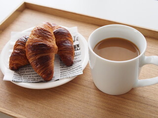 ウッドトレーにのせられたカフェオレとクロワッサン