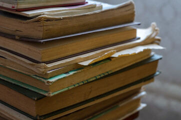 A stack of old books that have been read out. Textbooks and technical literature in close-up....