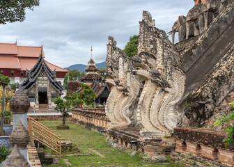 Base of main stupa with beautiful ancient naga and elephant stucco decor at Wat Chedi Luang buddhist temple, famous landmark of Chiang Mai, Thailand - obrazy, fototapety, plakaty