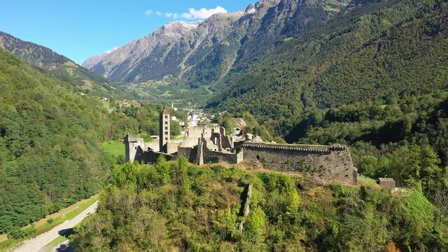 Mesocco castle ruins overlooking the road of the San Bernardino mountain pass in canton Graubunden in Switzerland. Shot with a forward and rotation motion. 