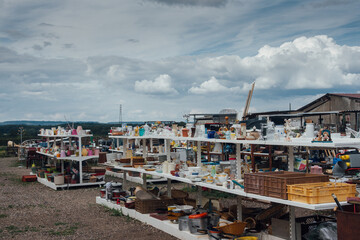 des étals dans une brocante extérieure. Un magasin Emmaüs 