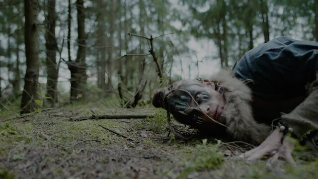 Young druid puts ear on ground to communicate with ghosts