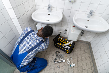 Plumber Fixing Pipe In Bathroom. Plumbing Maintenance