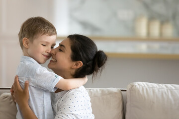 Affectionate caring happy young indian ethnicity woman showing tender feelings to smiling cute...