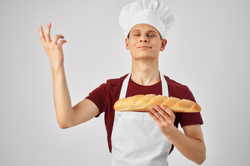 emotional male chef in a white apron loaf in the hands of cooking baking