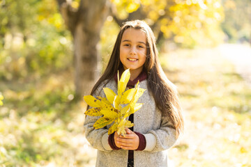 Adorable little girl outdoors at beautiful autumn day