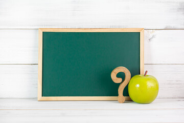 Greenboard , Green Apple and question mask sign on white wood background , empty board , problem...