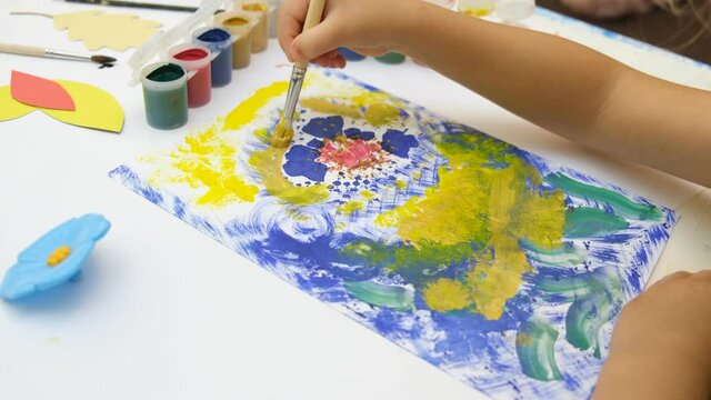 Little girl draws colorful abstract with flowers. Early development.  Children's creativity . The concept of a happy childhood. 