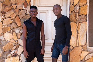 Fototapeta na wymiar Two handsome young Ghanaian men standing in front of a house