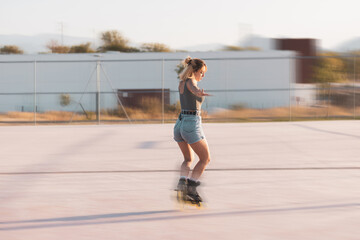 a very pretty girl riding on in-line skates on a basketball court.