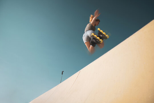 a very pretty girl riding on in-line skates on a basketball court.