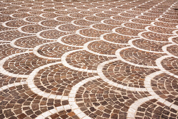 Classic pavement of an ancient Italian city, square stones mounted in mosaic as a road pavement