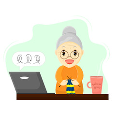 A happy grandmother at a table with a laptop is taking a knitting master class
