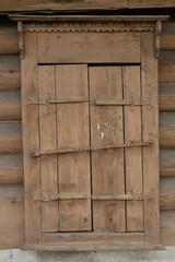 The window of an old wooden Russian house with beautiful shutters