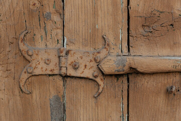 Antique curly hinges on old shutters