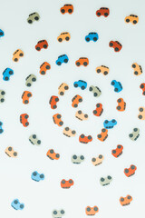 Texture of small multi-colored toy cars moving in a circle isolated on a white background, Top view depicts a circular motion