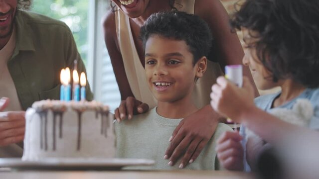Slow motion of boy blowing candles on birthday cake