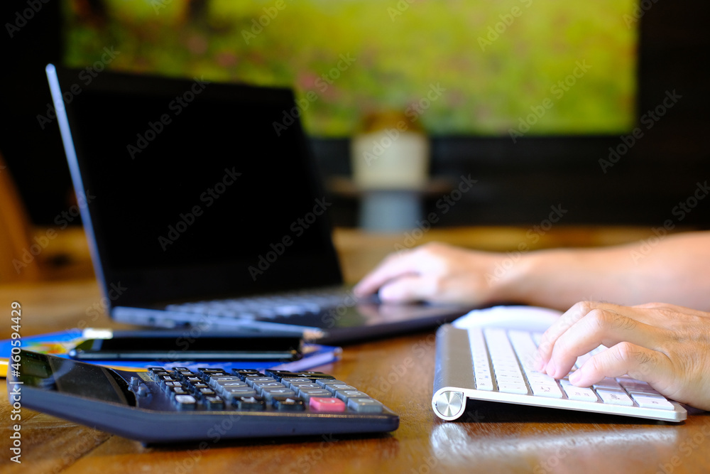 Poster businessman types on a computer keyboard at a wooden desk. banking and strategy development a financ