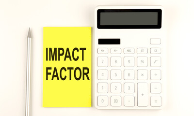 text IMPACT FACTOR on yellow sticker, next to pen and calculator