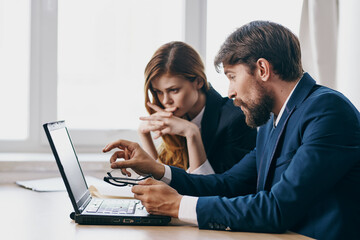 Obraz premium colleagues sitting at a desk with a laptop communication officials