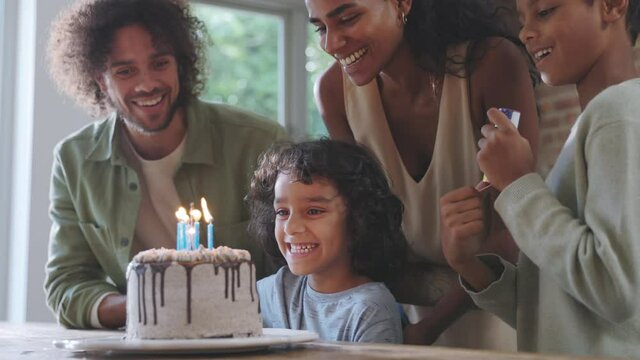 Slow motion of family with birthday with cake and party popper