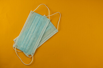 bunch of new blue masks laying on yellow background. Top view
