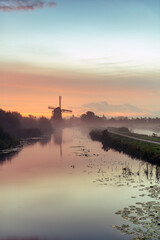 Fototapeta na wymiar Calm and foggy sunrise morning on the Hazerswouder-Dorp windmill, Rietveldse, Netherlands.