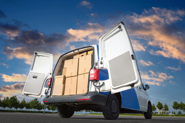 Express van. Minivan with open trunk. Express van on blue sky background. Lots of cardboard boxes...